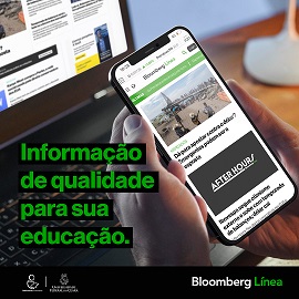 Fotografia mostrando uma mão segurando um smartphone. No aparelho é exibido o feed da Bloomberg Línea.